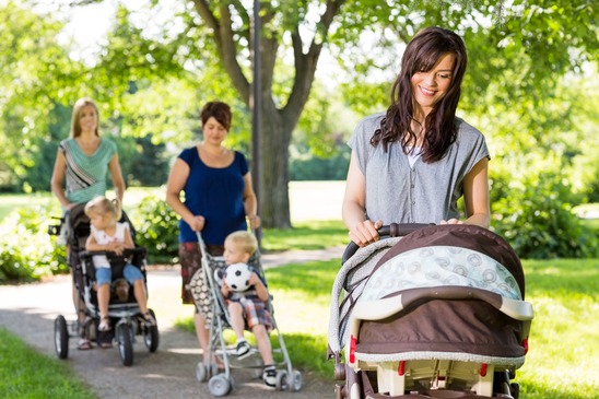 Mother Looking At Baby In Stroller At Park